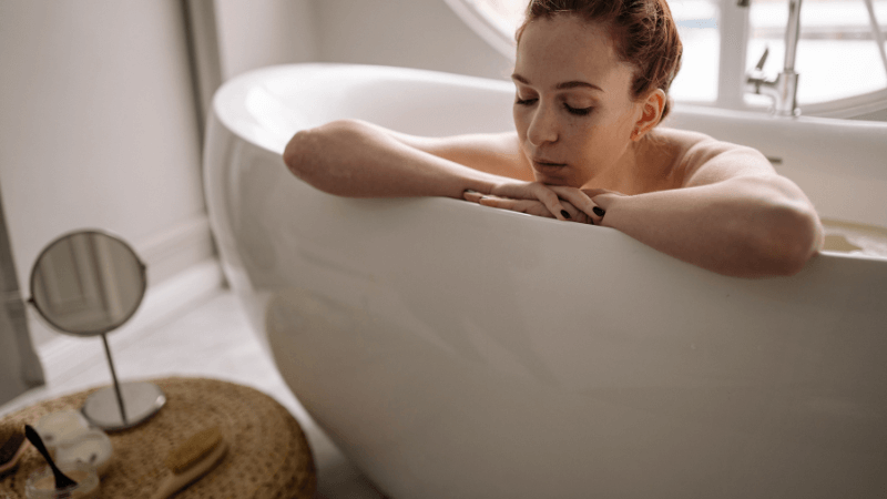 Beauty on a Budget: Affordable Bathroom Essentials. A young woman relaxing in a bathtube